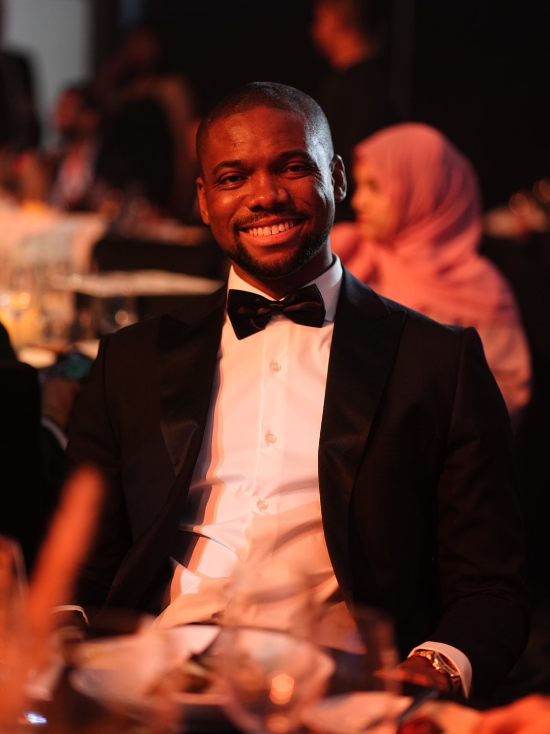Tonye Anyanwu wearing a black tuxedo at a formal event